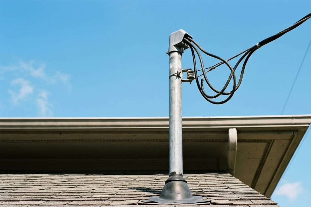 A service mast through a shingle roof with the weatherhead and drop attachment